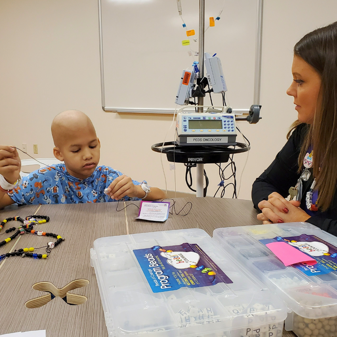 Child receiving Beads of Courage from Child Life Specialist