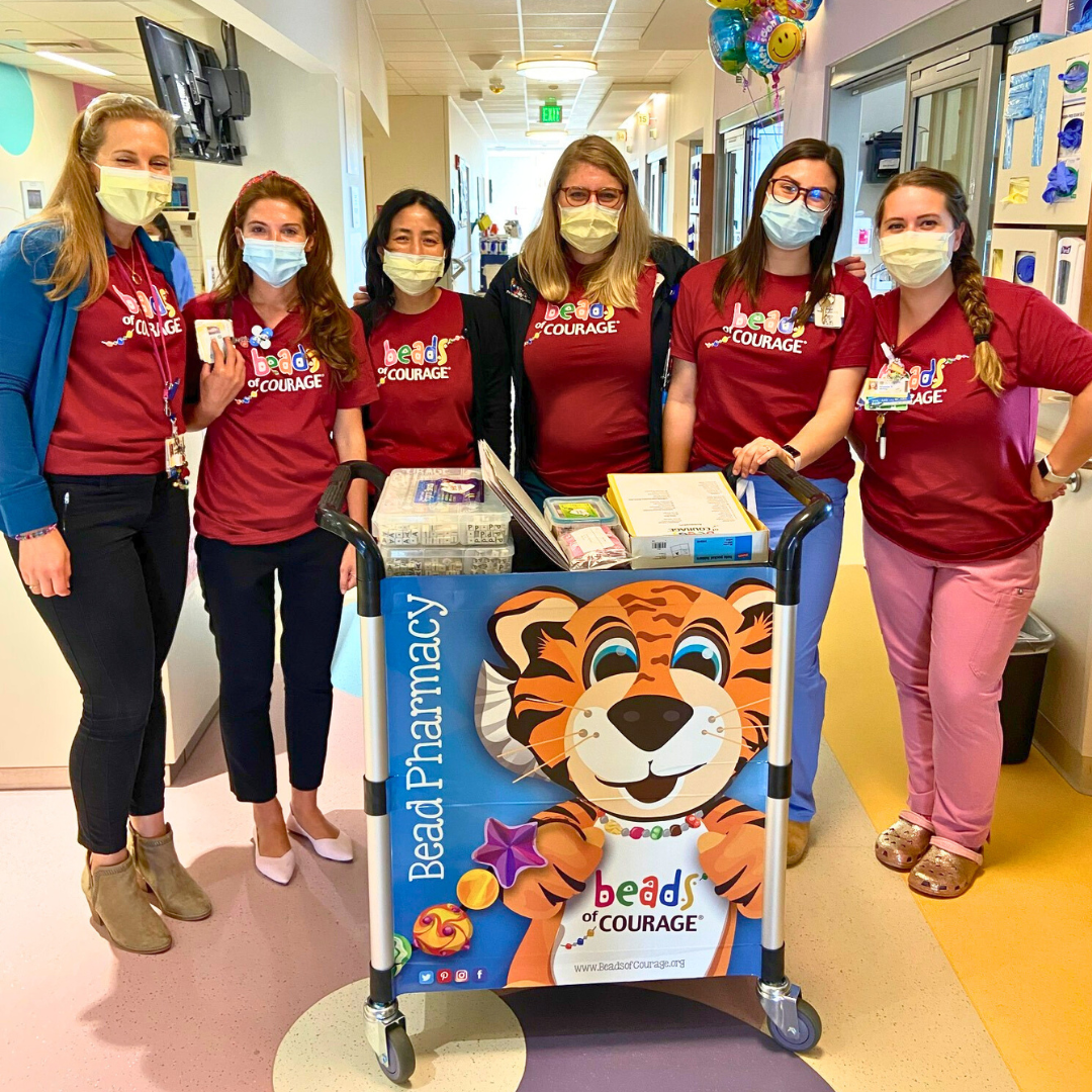 Hospital staff with Beads of Courage materials cart and wearing Beads of Courage shirts