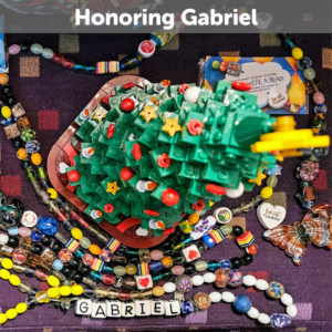 Beads of Courage displayed around a lego christmas tree and in lower right corner, bereavement butterfly bead honoring Gabriel